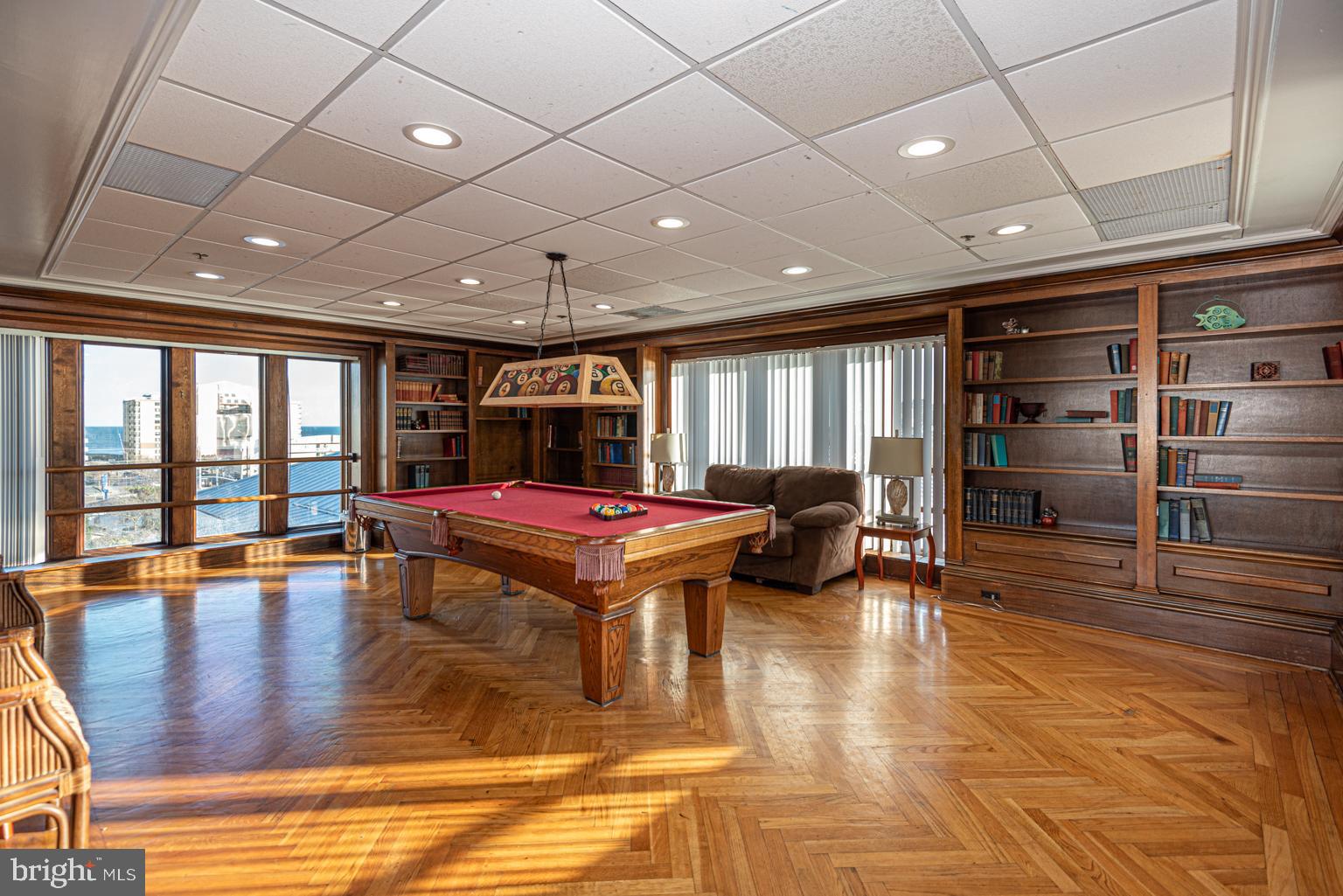 200 59th Street, Unit 209 Ocean City, MD 21842 - Photo 45 of 49 a room with lots of furniture and wooden floors