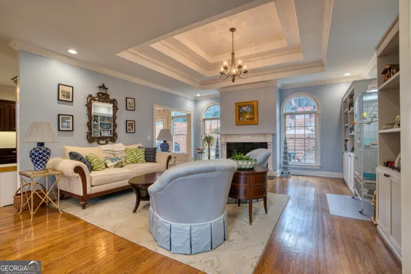a living room with furniture and a chandelier