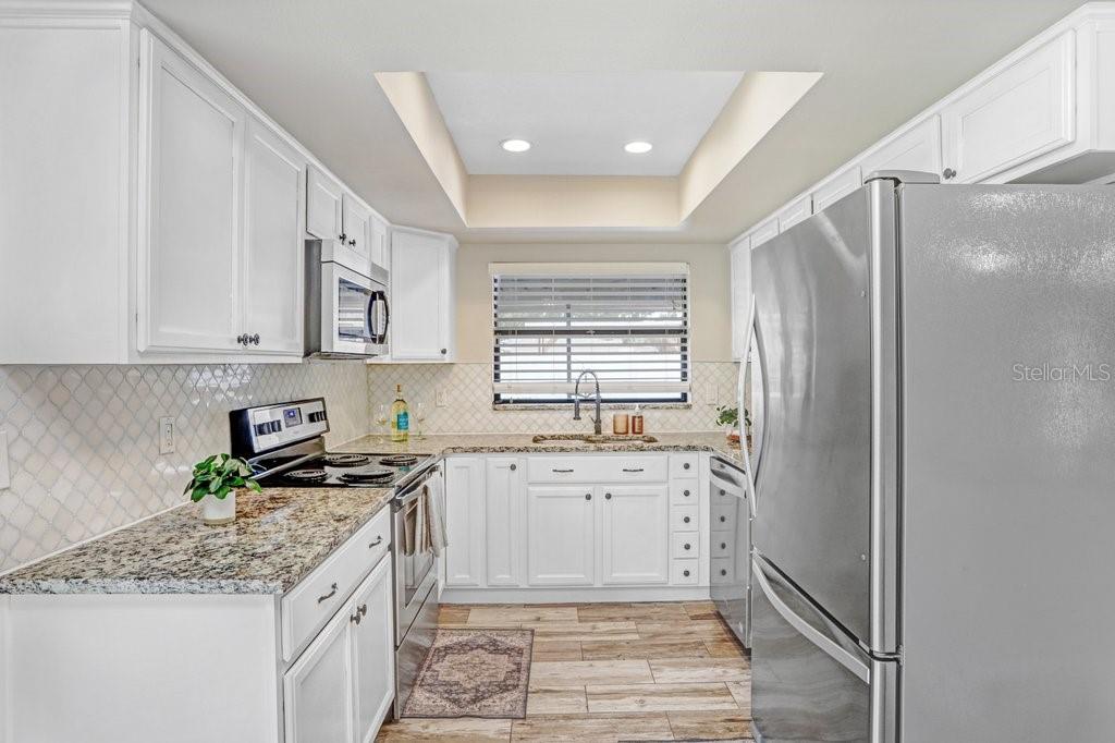 4412 Stonehenge Road Tampa, FL 33624 - Photo 15 of 33 a kitchen with stainless steel appliances granite countertop a sink stove and refrigerator