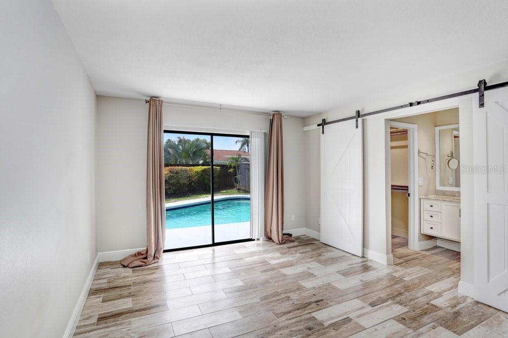 4412 Stonehenge Road Tampa, FL 33624 - Photo 17 of 33 an empty room with wooden floor and windows