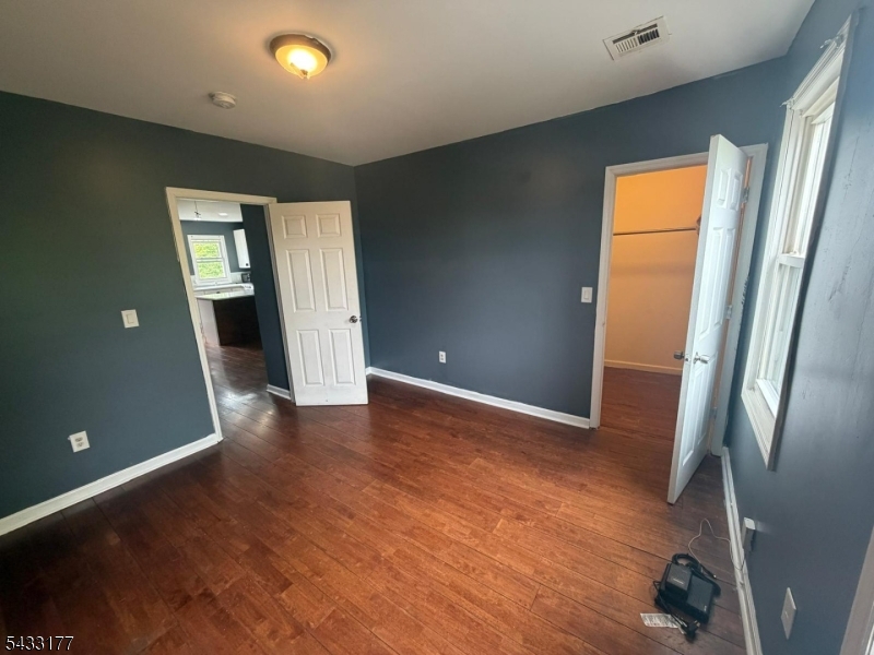 166 Renner Avenue, Unit 3 Newark, NJ 07112 - Photo 22 of 24 an empty room with wooden floor and a window