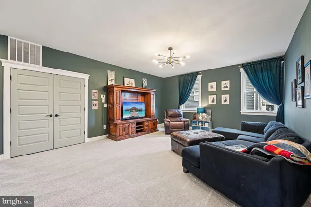 a living room with furniture large window and wooden floor