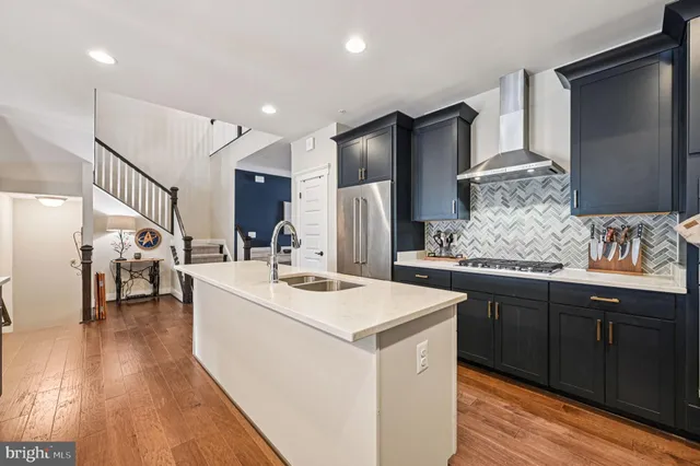 a kitchen with stainless steel appliances granite countertop a refrigerator and a sink