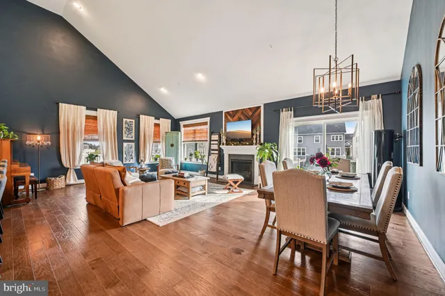 a living room with furniture kitchen view and a large window