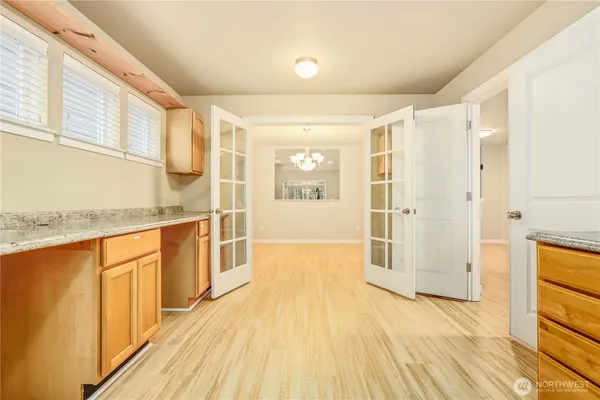 a view of a kitchen with wooden floor and a window