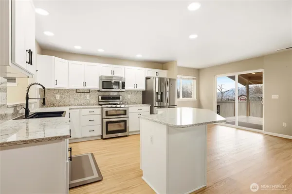 a kitchen with stainless steel appliances granite countertop a sink stove and refrigerator