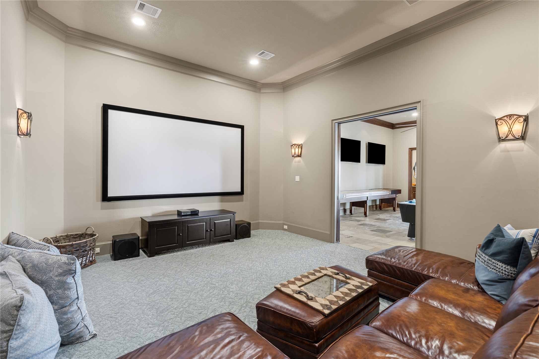 12349 Longmire Trace Conroe, TX 77304 - Photo 18 of 48 Dedicated media room with ceiling-mounted projector, large screen, crown molding, and soft recessed lighting.