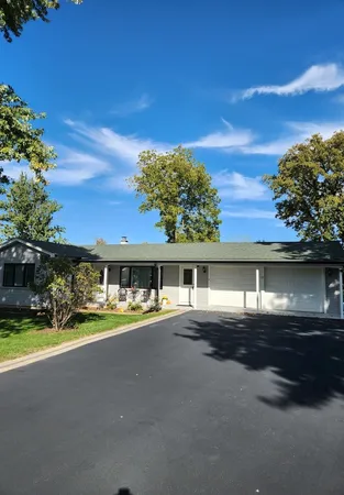 a view of a house with a yard and sitting area