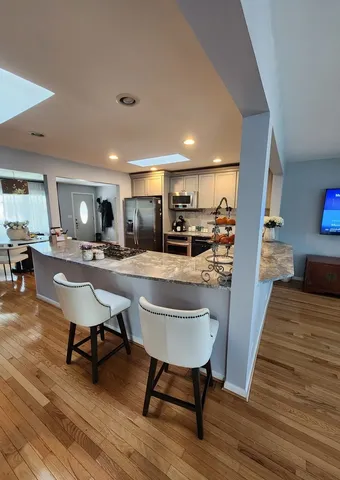 a view of a dining room with furniture a rug and wooden floor