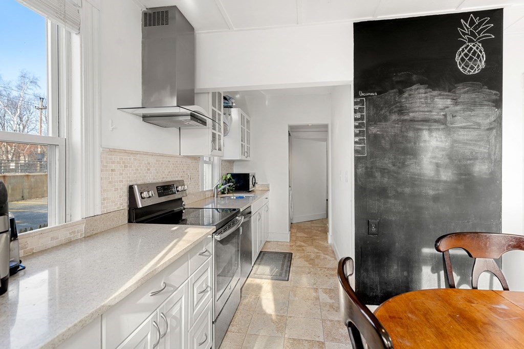 98 Pine Street Swampscott, MA 01907 - Photo 12 of 37 a kitchen with a stove a refrigerator and furniture