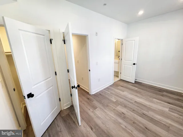 an empty room with wooden floor and entrance