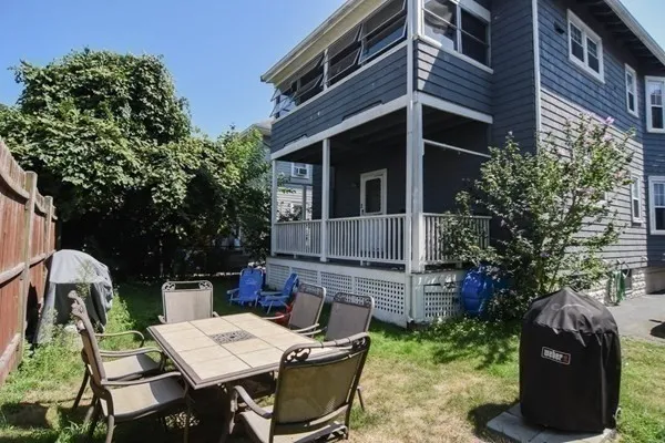 a backyard of a house with table and chairs