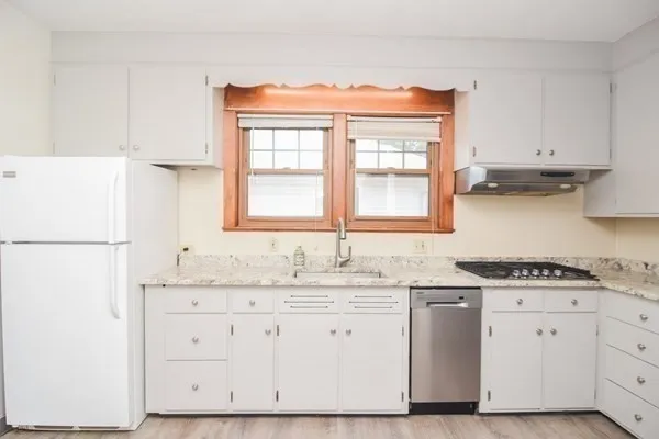 a kitchen with granite countertop a sink stainless steel appliances and cabinets
