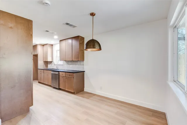 a kitchen with granite countertop a sink cabinets and stainless steel appliances