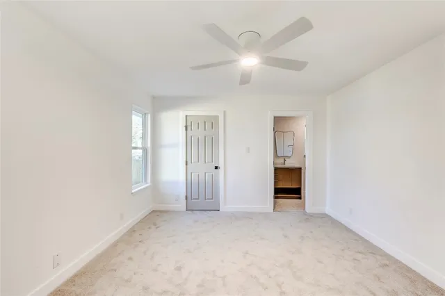 a view of an empty room with closet and a window
