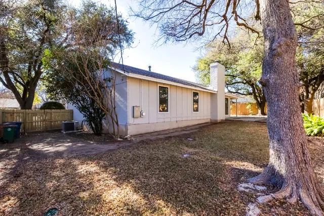 a view of a house with a large tree and a yard