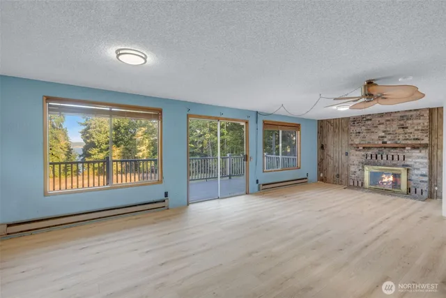 a view of an empty room with a fireplace and a window
