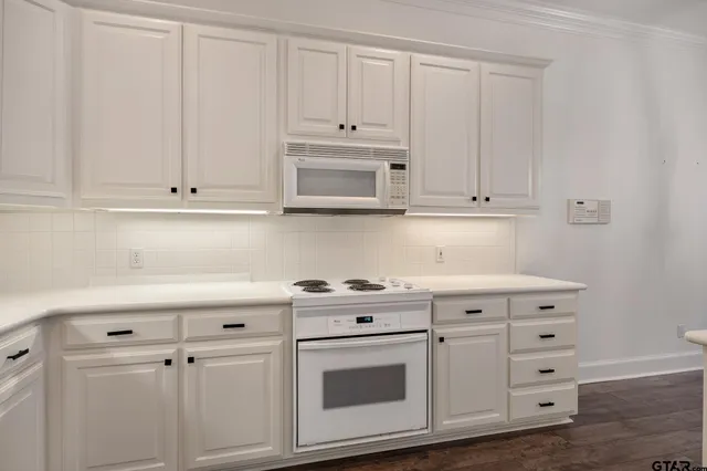 a kitchen with white cabinets and white appliances