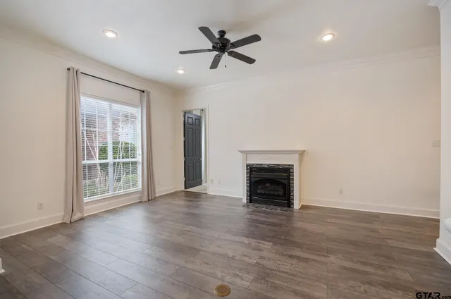 an empty room with fireplace wooden floor and windows