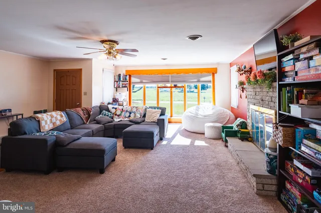 a living room with furniture a bookshelf and a window