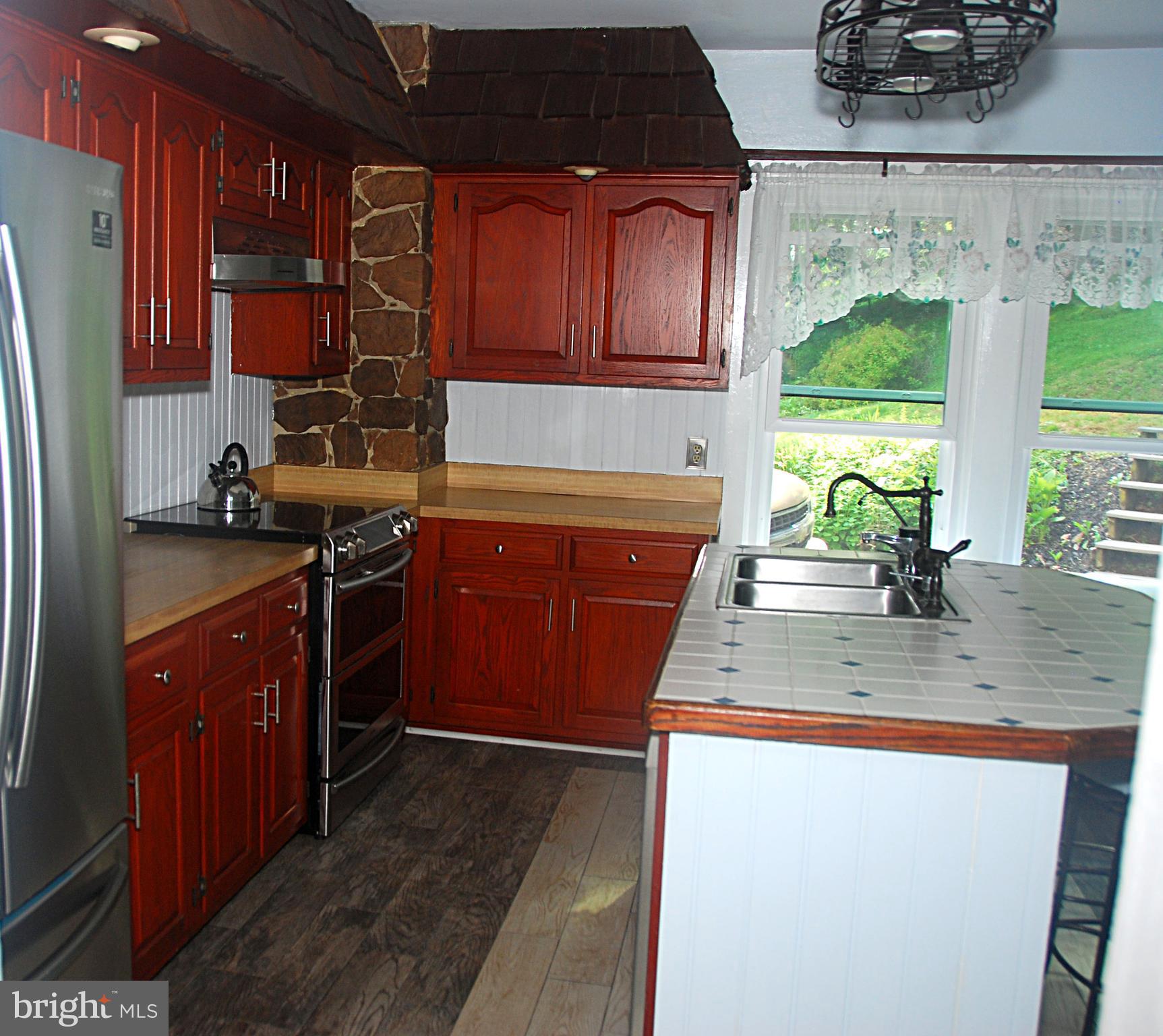 121 Chesterville Road Landenberg, PA 19350 - Photo 19 of 35 a kitchen with stainless steel appliances granite countertop wooden cabinets a stove a sink and a large window