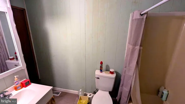 a bathroom with a toilet and a shower curtain