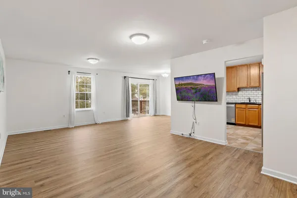 a view of a kitchen with wooden floor and electronic appliances