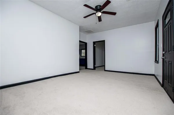 an empty room with a ceiling fan and a window