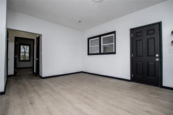 a view of an empty room with closet and a window