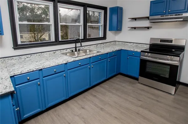 a kitchen with granite countertop wooden cabinets a sink and a window