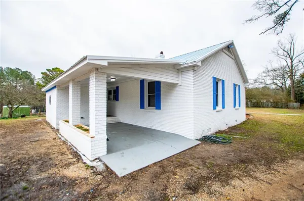 a view of a house with backyard and trees