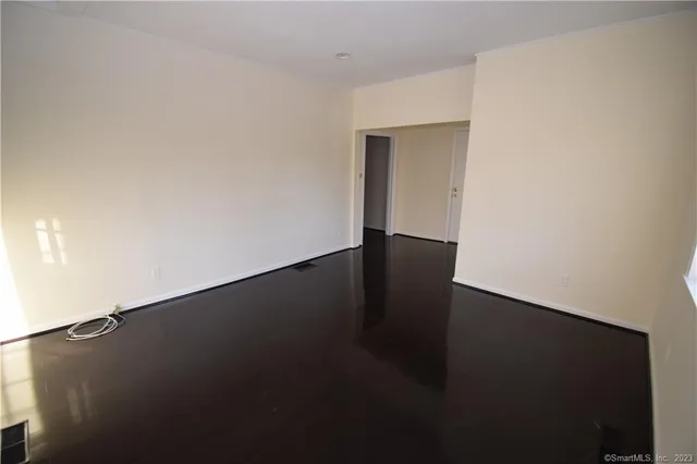 a view of an empty room with wooden floor
