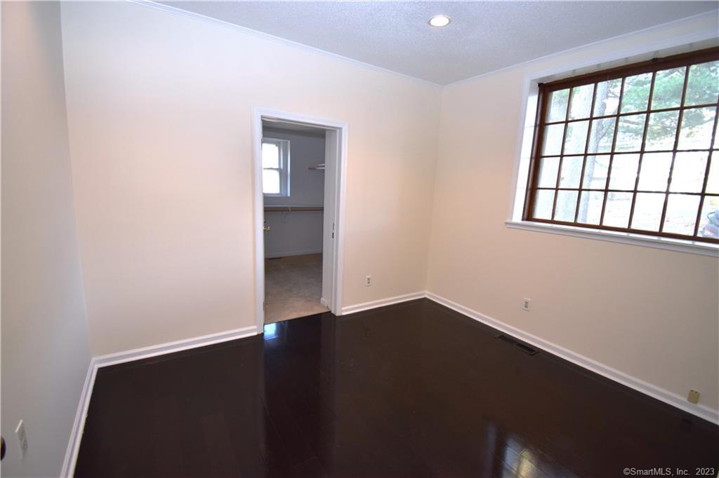 159 Main Street, Unit E Chester, CT 06412 - Photo 10 of 17 an empty room with wooden floor and windows