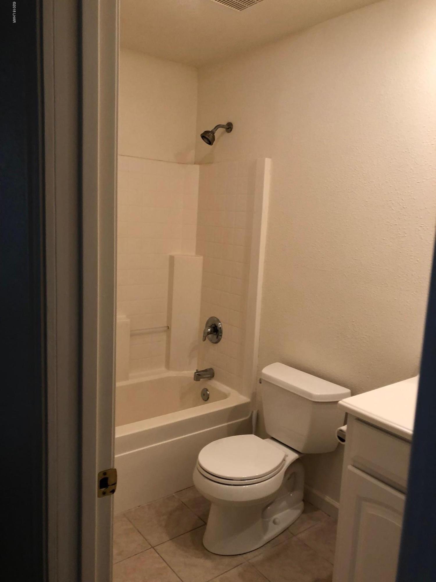 3739 Hope Road Golden Valley, AZ 86413 - Photo 14 of 26 a white toilet and tub sitting next to a bathroom sink