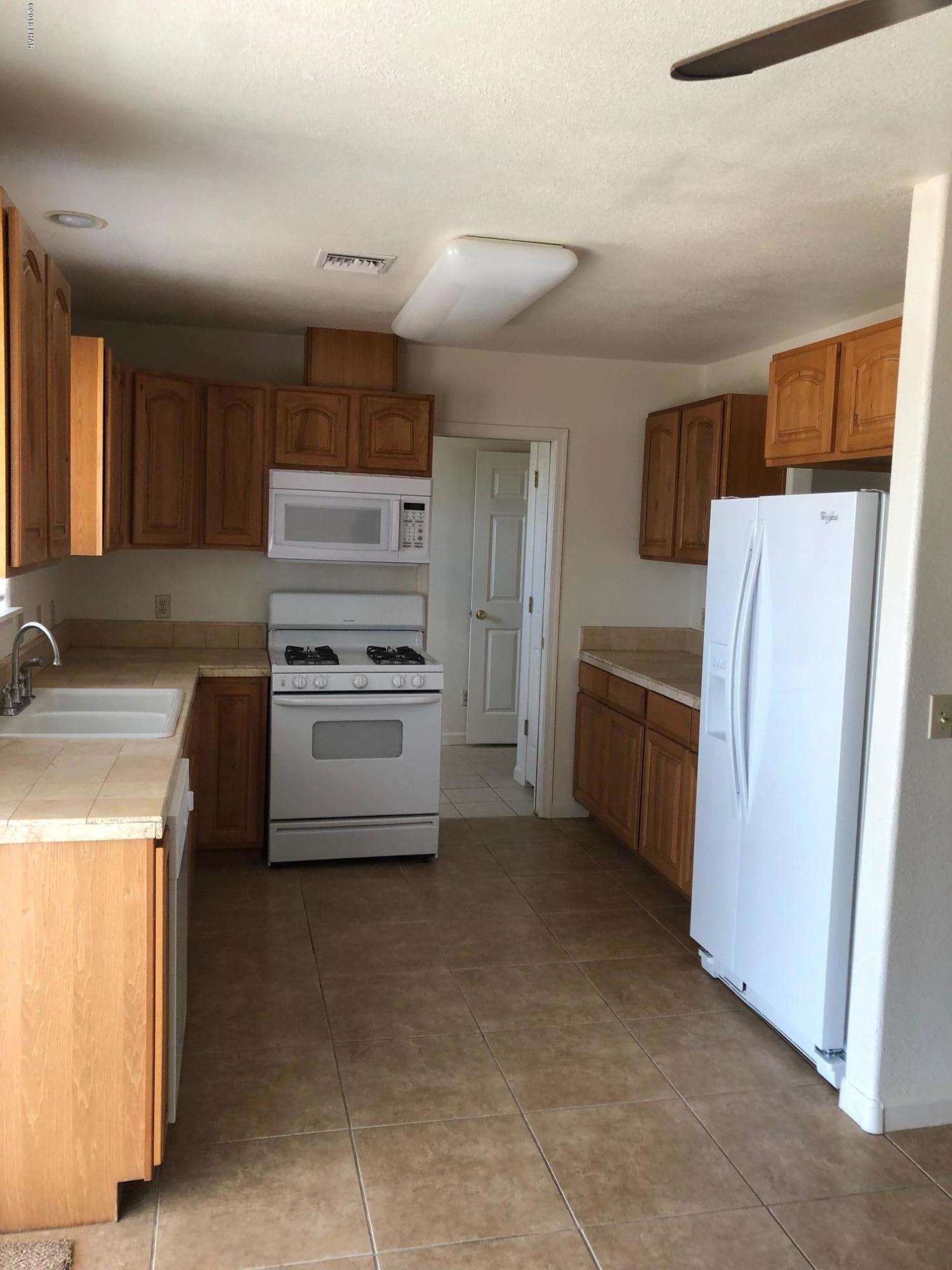 3739 Hope Road Golden Valley, AZ 86413 - Photo 5 of 26 a kitchen with a refrigerator sink stove and cabinets