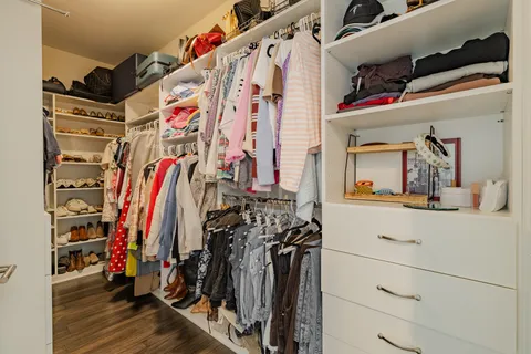 a view of walk in closet with clothes