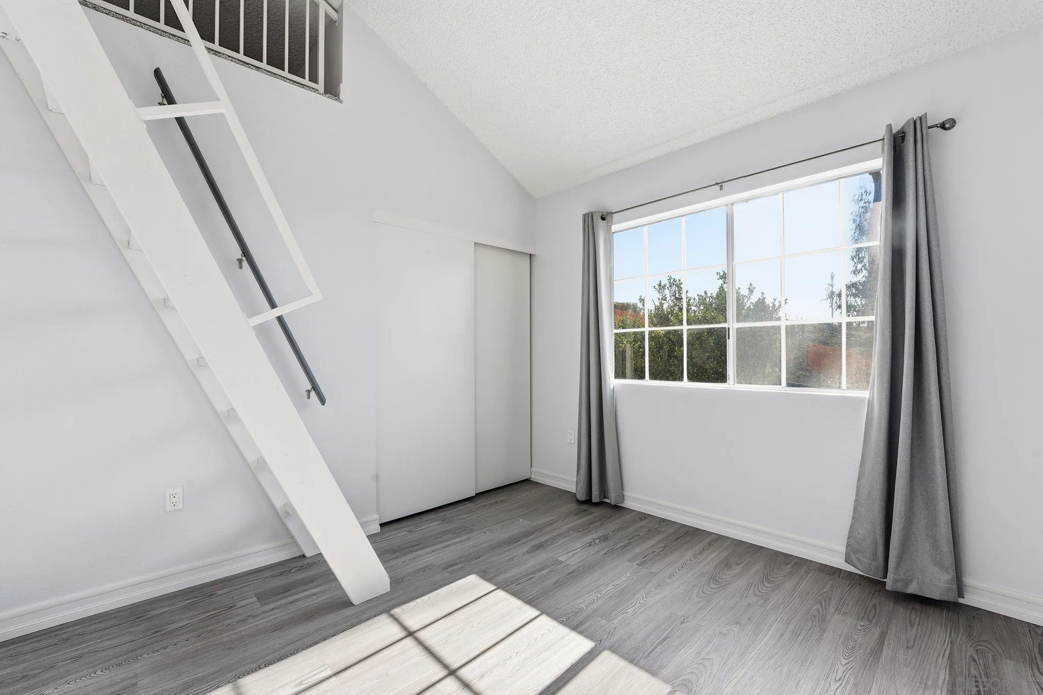 8753 Spring Canyon Drive Spring Valley, CA 91977 - Photo 27 of 43 a view of a room with wooden floor and white walls