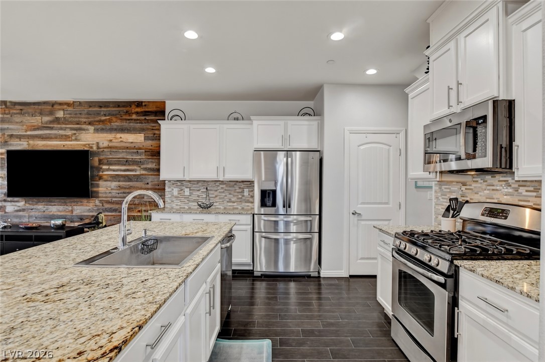 48 Jasmine Point Street Henderson, NV 89074 - Photo 23 of 62 Granite counters, stainless steel appliances, and sleek tile flooring define this modern kitchen.