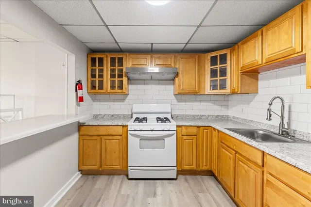 a kitchen with a sink appliances cabinets and a window