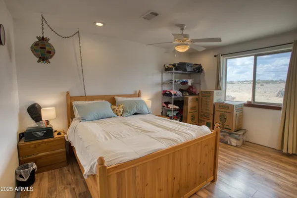 a bedroom with a bed and wooden floor