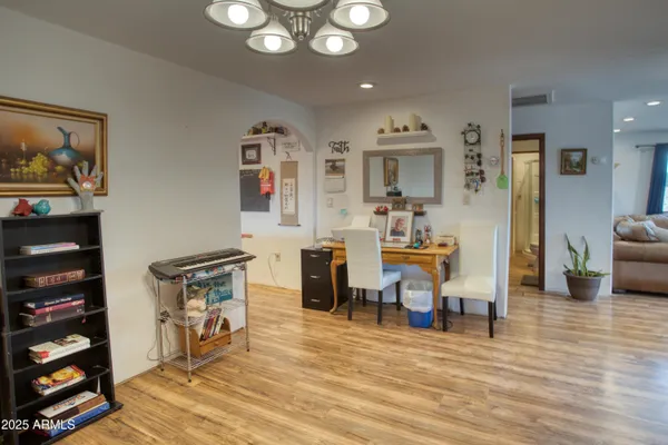 a view of a dining room with furniture a chandelier and wooden floor