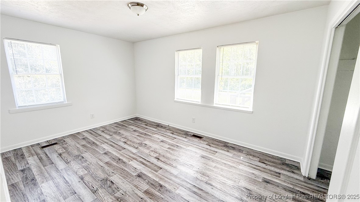 666 Jacobs Road Maxton, NC 28364 - Photo 17 of 30 an empty room with wooden floor and windows