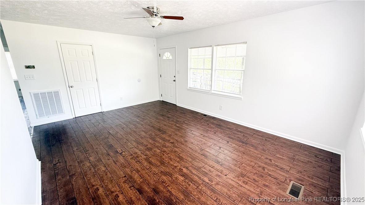 666 Jacobs Road Maxton, NC 28364 - Photo 26 of 30 an empty room with wooden floor fan and windows