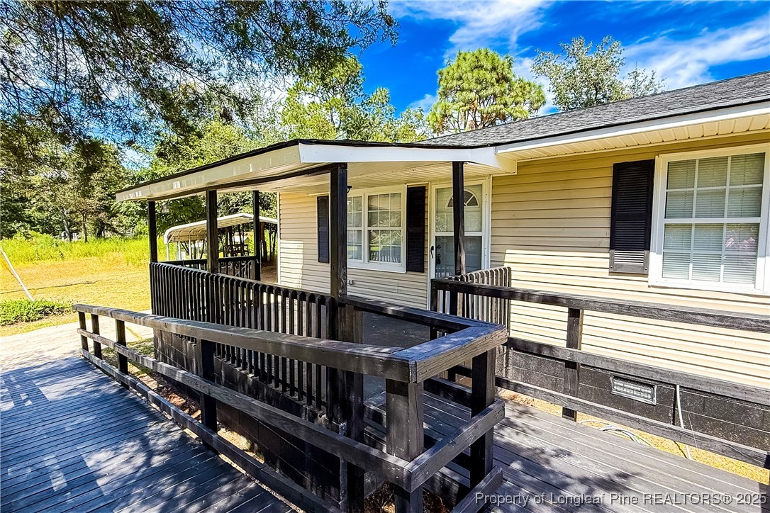 666 Jacobs Road Maxton, NC 28364 - Photo 5 of 30 a view of a house with wooden deck and furniture