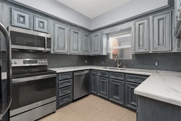 a kitchen with stainless steel appliances granite countertop a stove microwave and cabinets