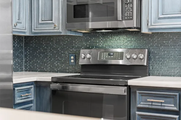 a kitchen with stainless steel appliances granite countertop a stove and a microwave