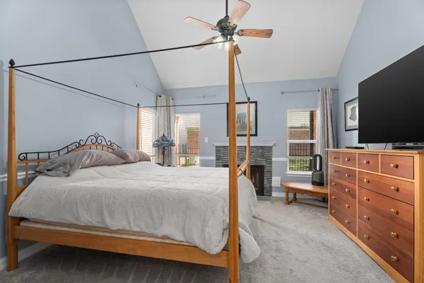 a bedroom with a bed and a flat tv screen on the dresser