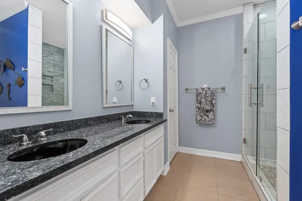 a bathroom with a granite countertop sink a mirror and a shower