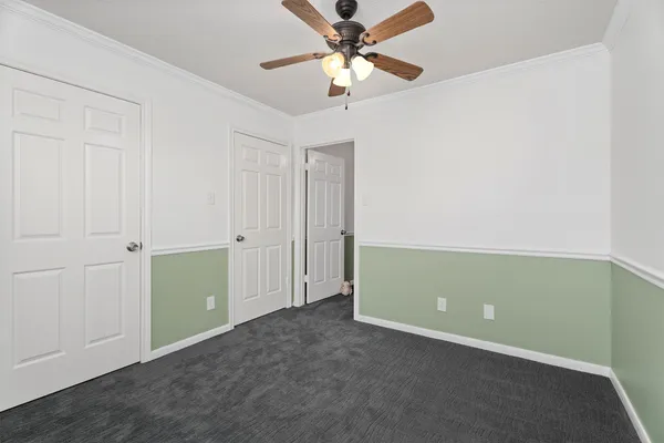 an empty room with closet and fan