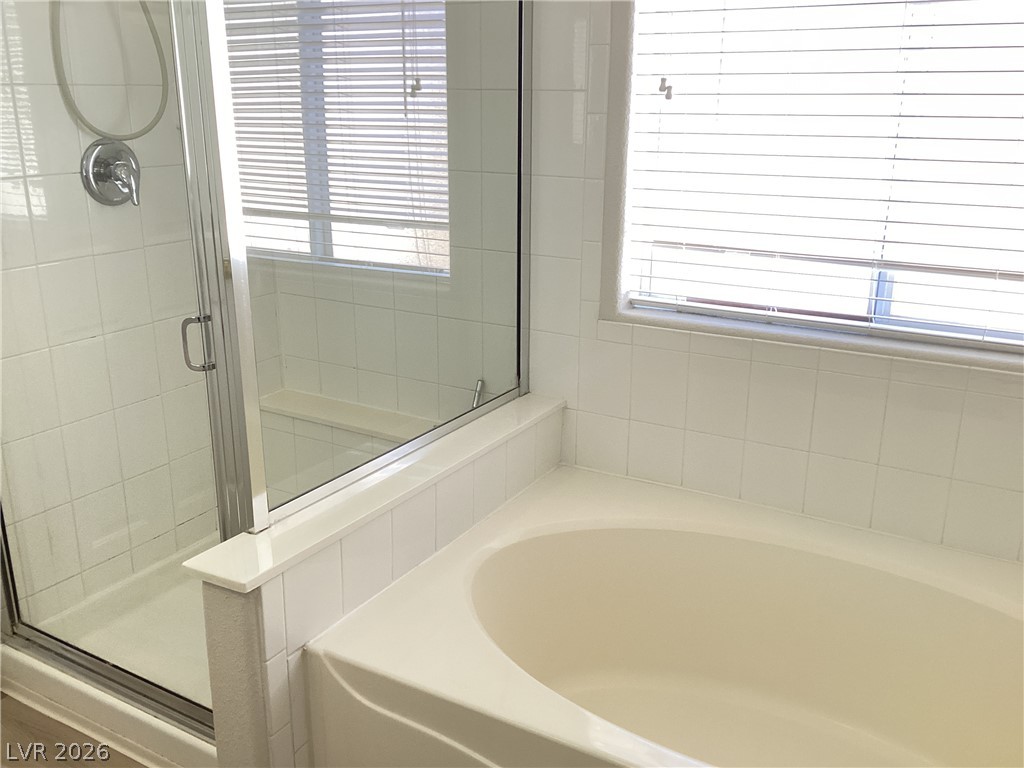 2135 Hidden Ranch Terrace Henderson, NV 89052 - Photo 19 of 27 A well-appointed bathroom features a generously sized soaking tub and a sleek glass-enclosed shower.